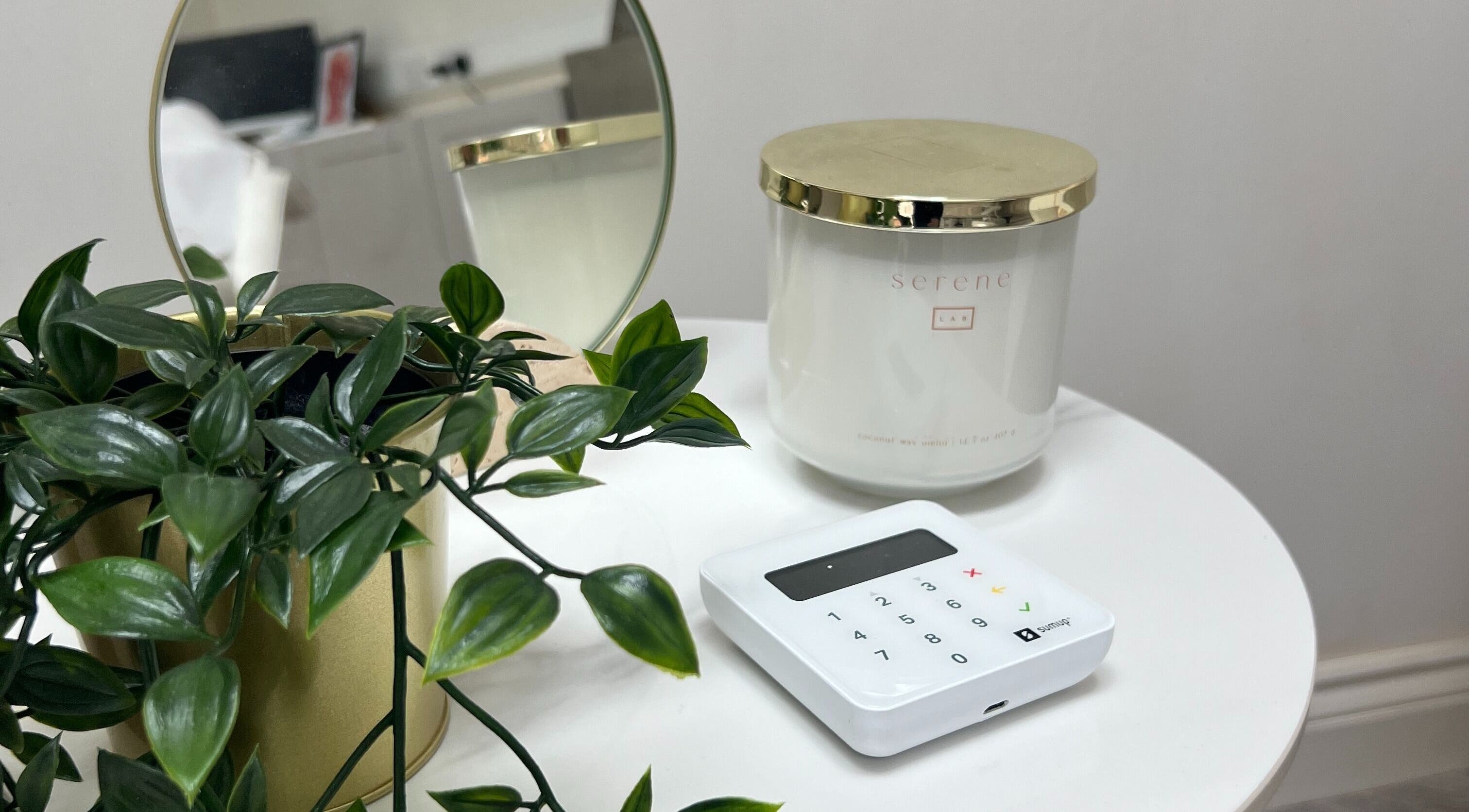 Elegant decor at The Cheshire Retreat Academy Ltd, Hale, England, with a candle and plant on a white table.