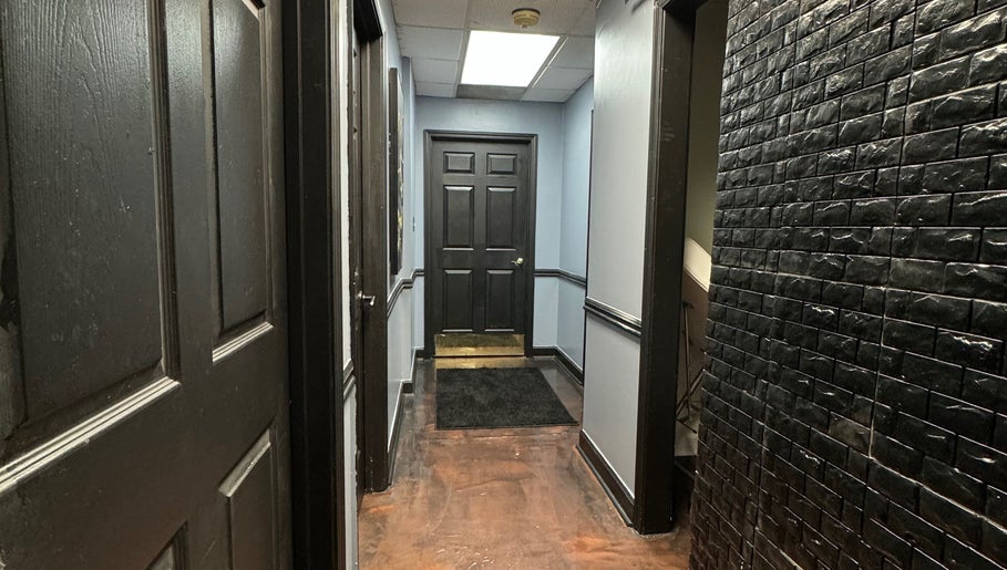 Elegant hallway at Getrightwjessy, Decatur, Georgia, US, featuring sleek black panel doors and textured walls.