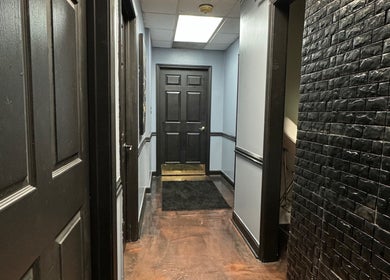 Elegant hallway at Getrightwjessy, Decatur, Georgia, US, featuring sleek black panel doors and textured walls.