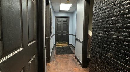 Elegant hallway at Getrightwjessy, Decatur, Georgia, US, featuring sleek black panel doors and textured walls.