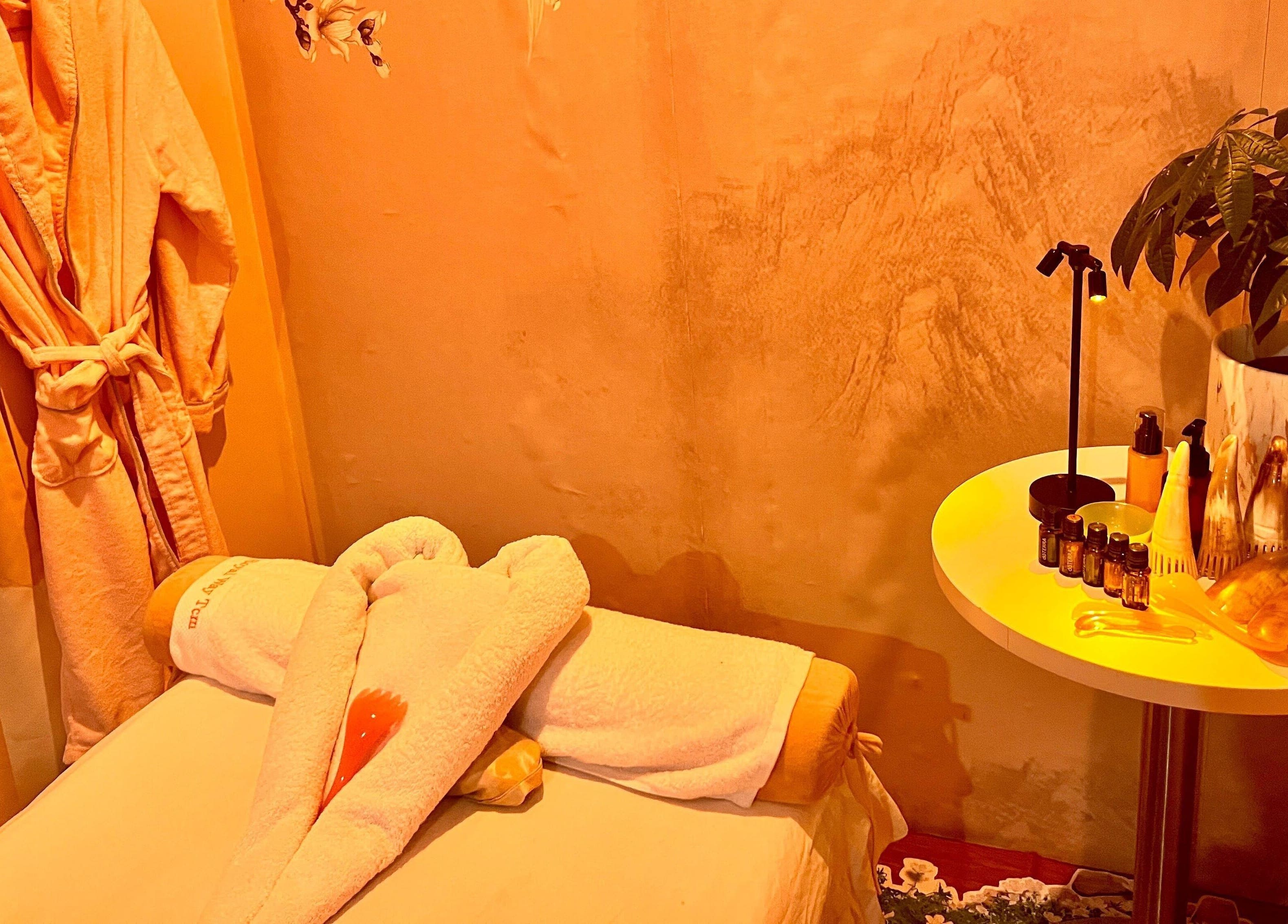 Relaxing massage room at RoyalwayTCM 御道中医 in Singapore with robe, towels, and soothing decor.