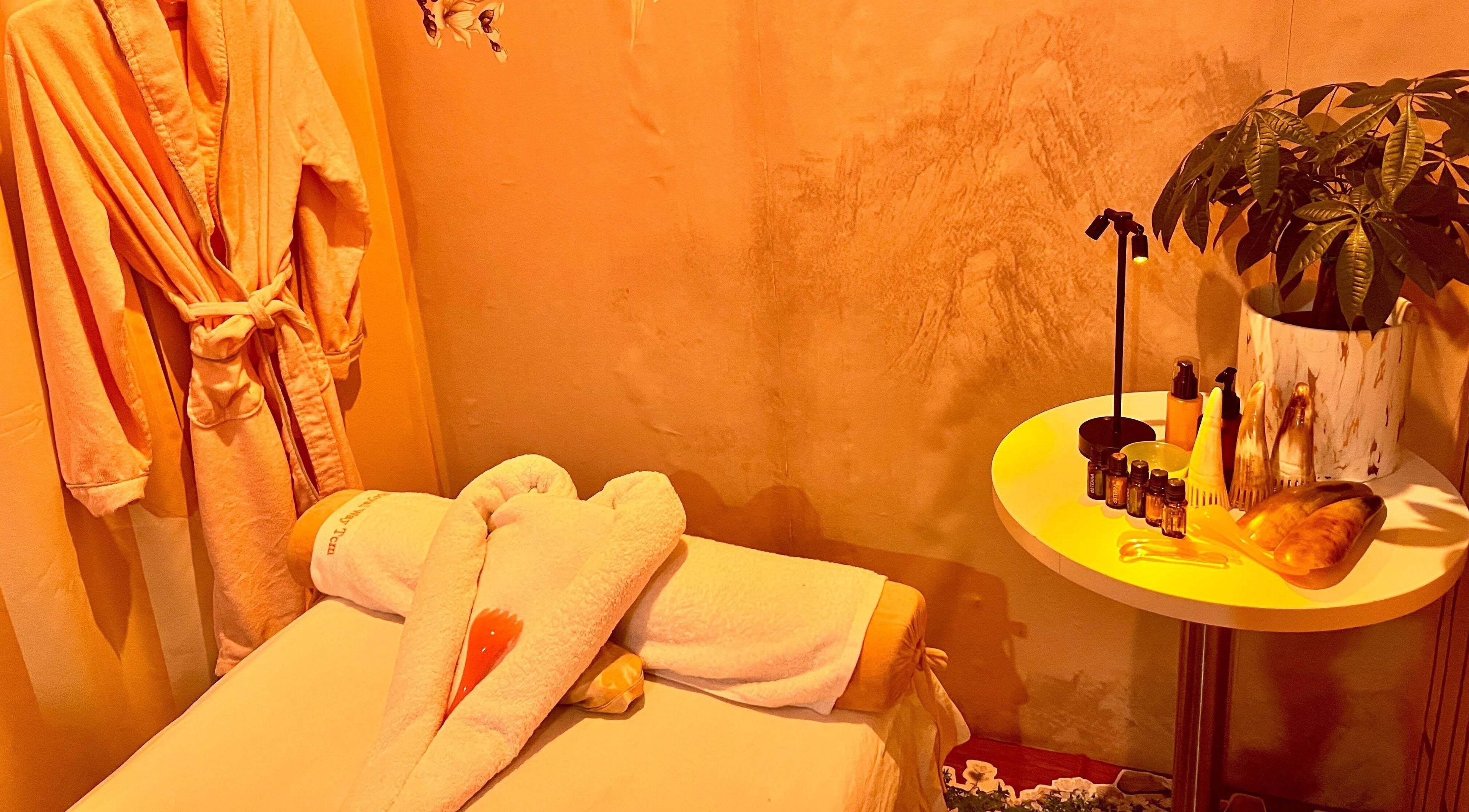 Relaxing massage room at RoyalwayTCM 御道中医 in Singapore with robe, towels, and soothing decor.