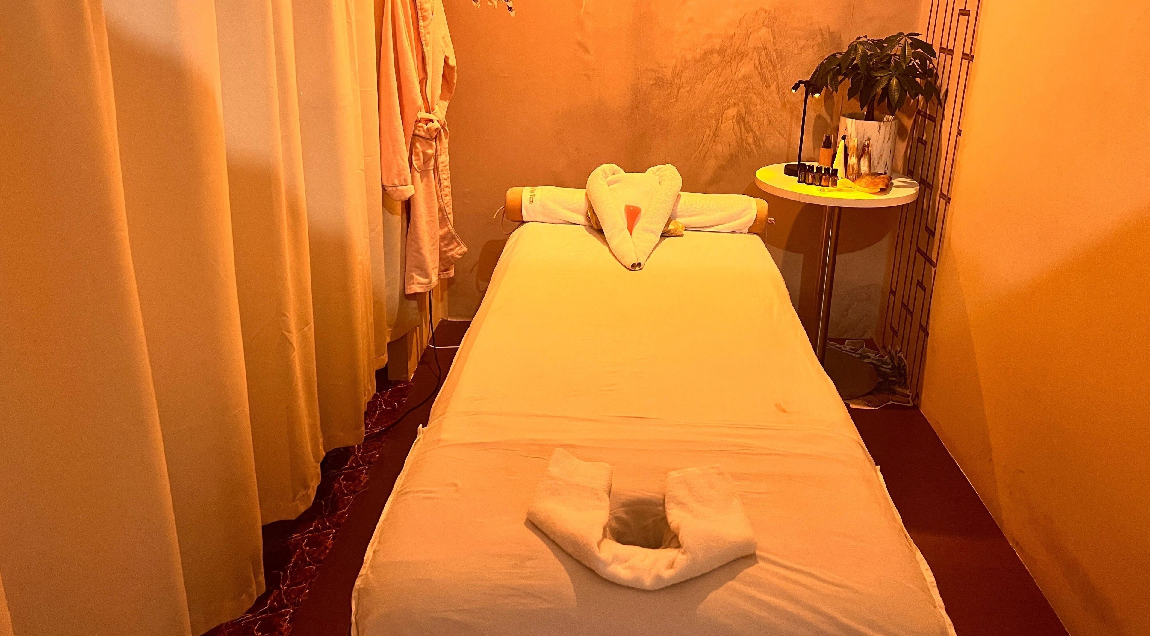 Cozy massage room at RoyalwayTCM 御道中医, Singapore, featuring a serene setup with warm lighting.