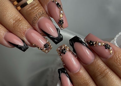 Detailed nail art with black and gold embellishments at Meraki Beauty Studio, Liverpool, England, GB.