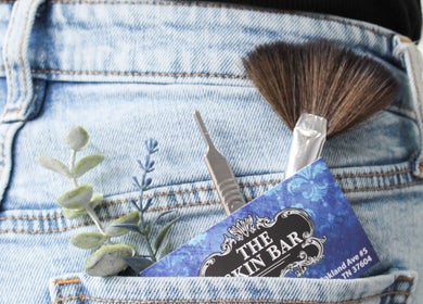 Tools and card from The Skin Bar and Body Boutique LLC in denim pocket, Johnson City, Tennessee, US.
