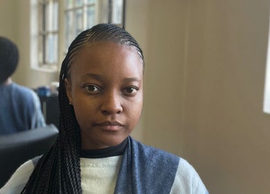 Customer with braided hair at Vanity Beauty Bar, Pretoria, Gauteng, ZA, enjoying a serene beauty experience.