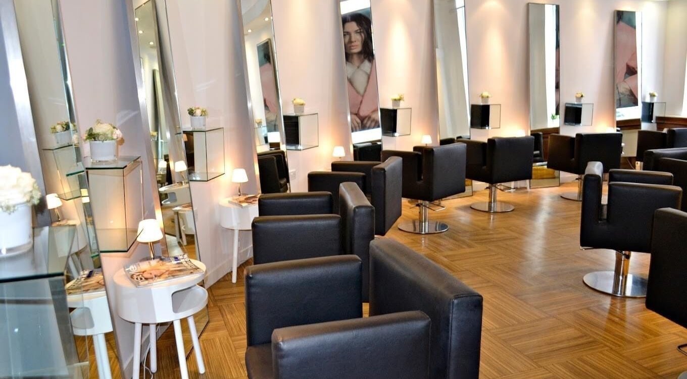Stylish interior of The Bank Hair & Beauty in Kirkcaldy, Scotland, GB featuring chic black chairs and mirrors.