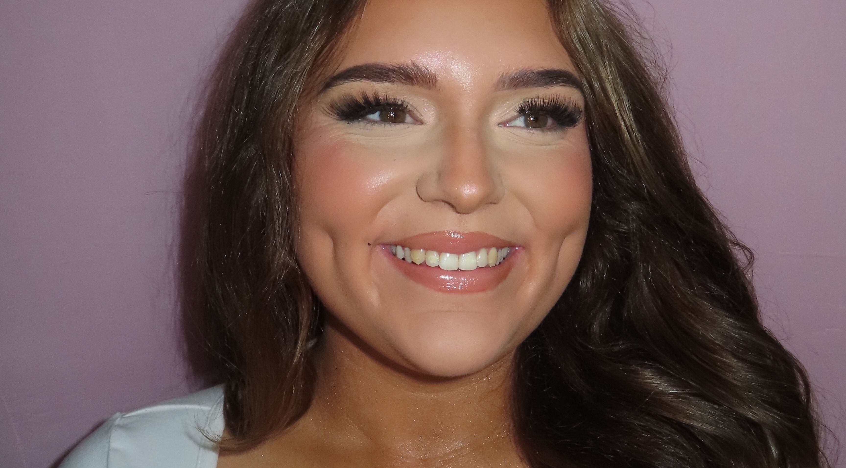 Close-up of a smiling woman showcasing flawless makeup at Dazzle Den, Douglas, Douglas, IM.