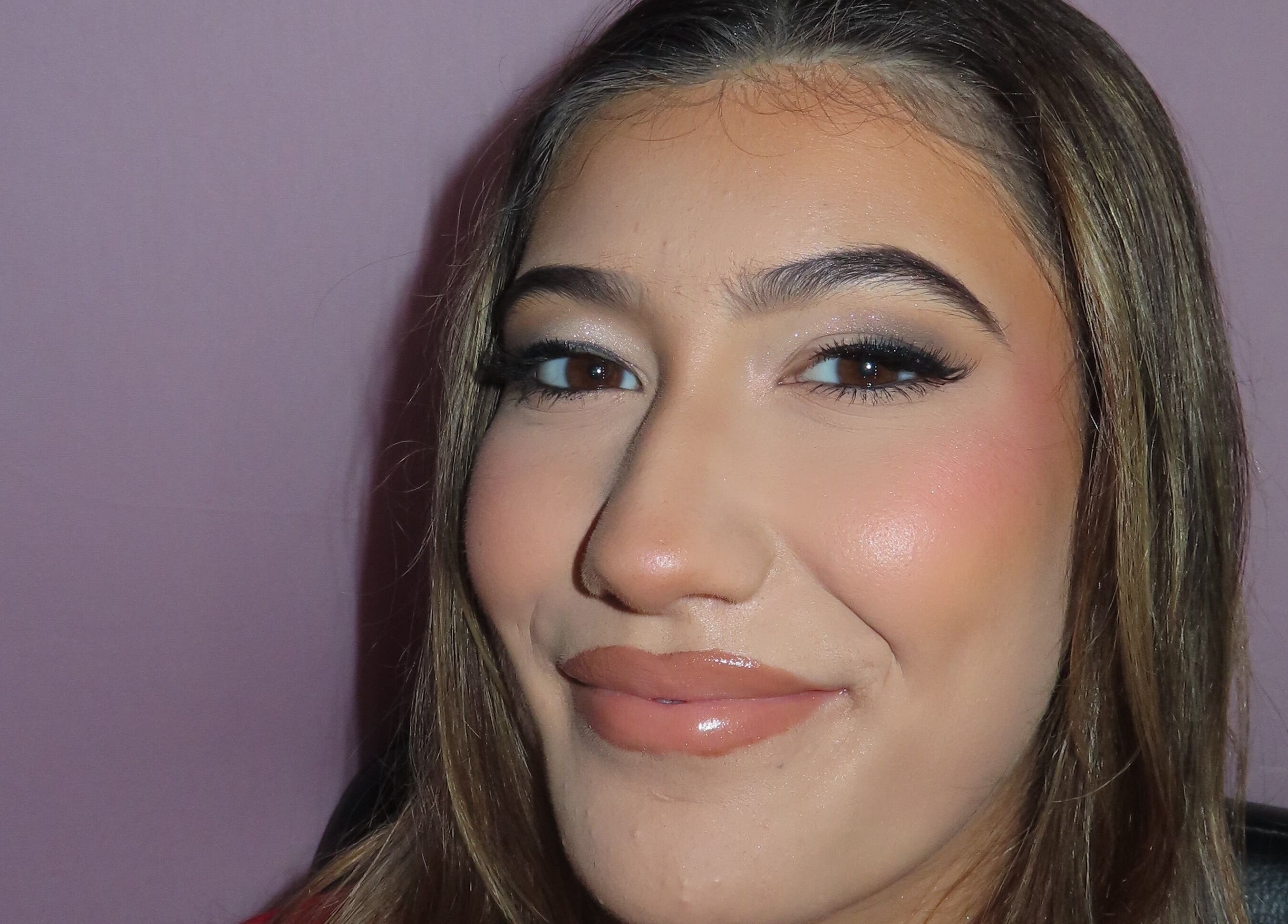 Close-up of a woman's face with flawless makeup at Dazzle Den, Douglas, Douglas, IM.