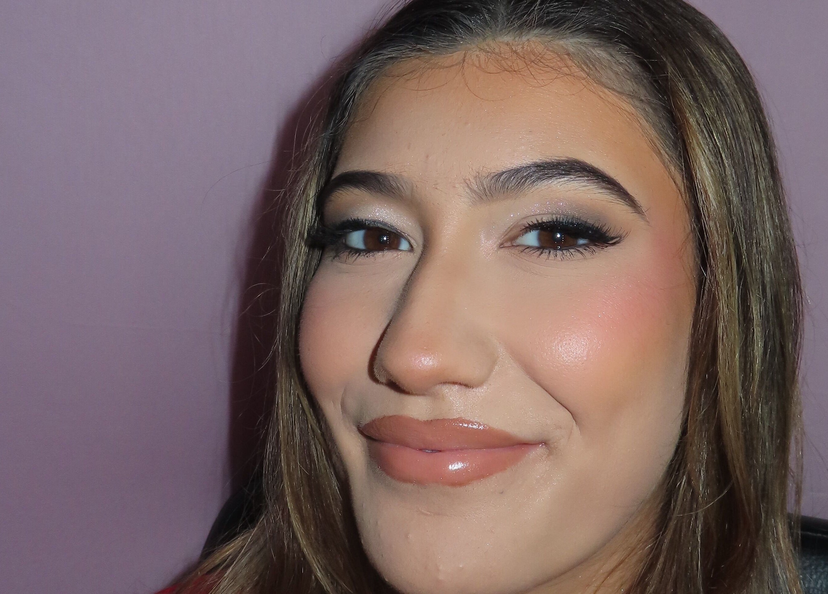 Close-up of a woman's face with flawless makeup at Dazzle Den, Douglas, Douglas, IM.