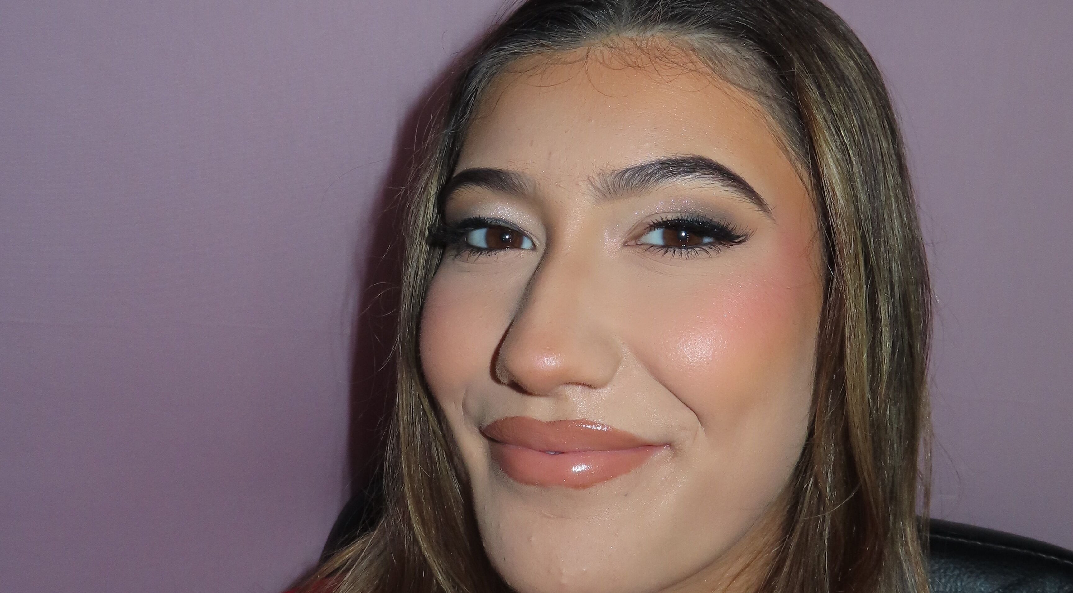 Close-up of a woman's face with flawless makeup at Dazzle Den, Douglas, Douglas, IM.