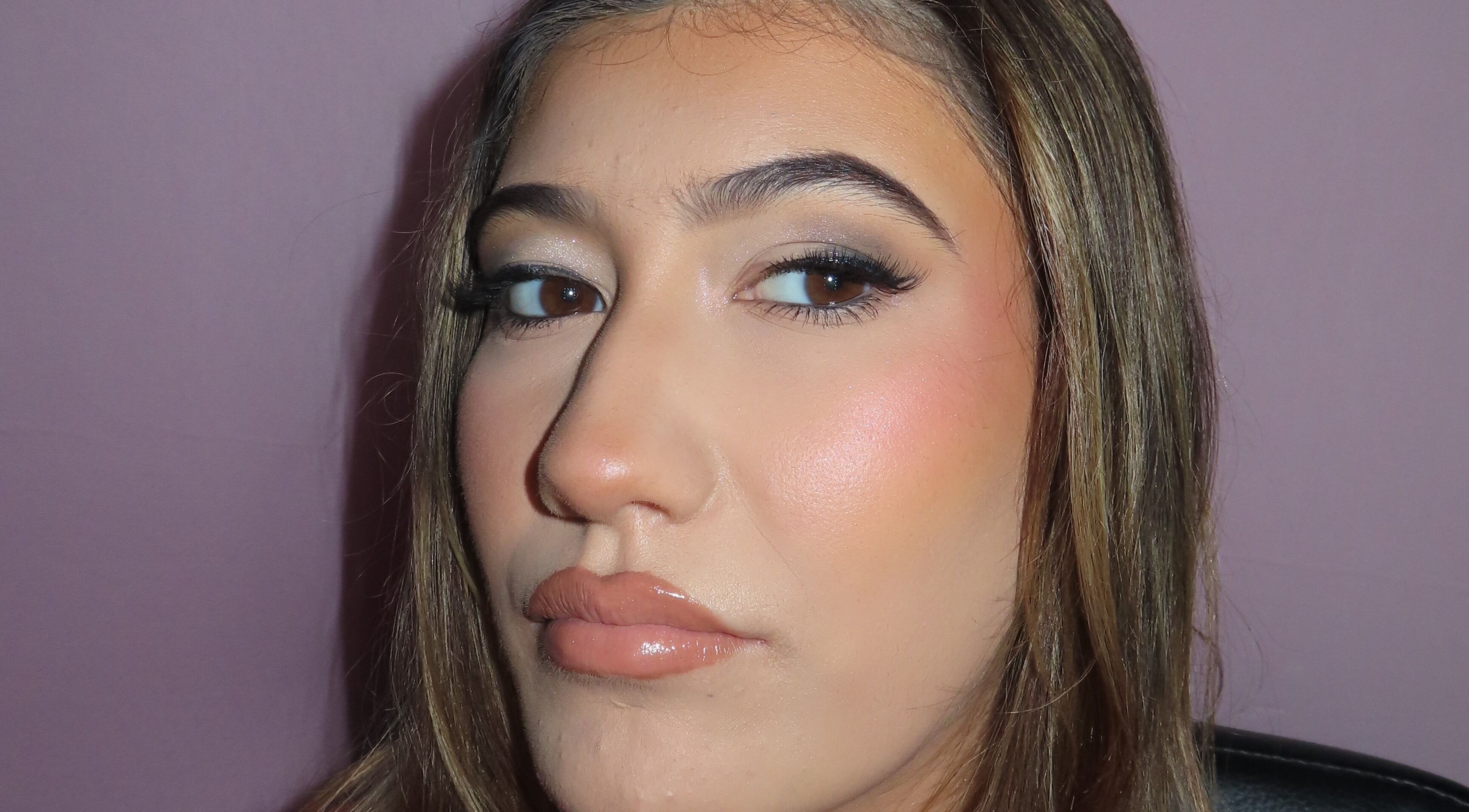 Close-up of a woman's face with flawless makeup at Dazzle Den, Douglas, Douglas, IM.