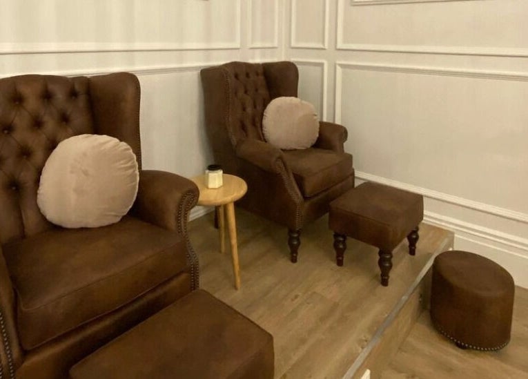 Cozy seating area at The Art of Nails Commercial Bay, Auckland, NZ, showcasing plush chairs and chic decor.