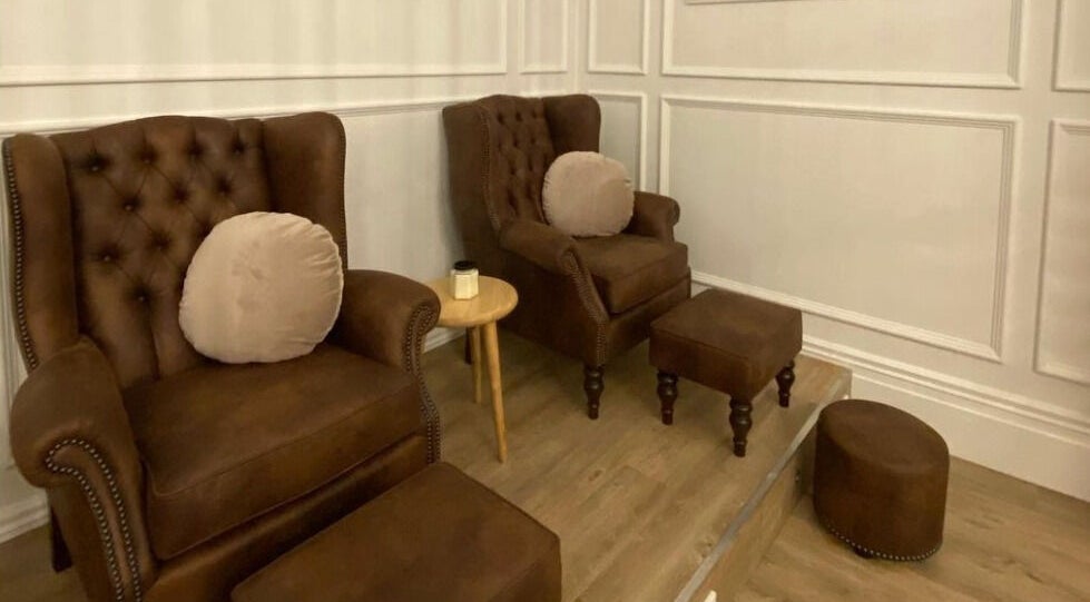 Cozy seating area at The Art of Nails Commercial Bay, Auckland, NZ, showcasing plush chairs and chic decor.