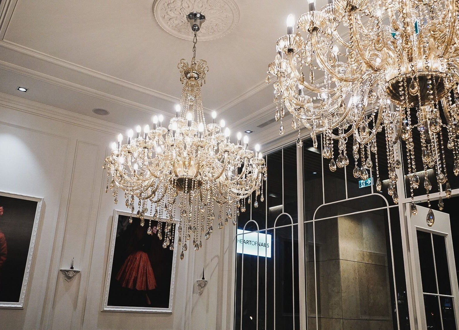 Luxurious chandeliers illuminate The Art of Nails Commercial Bay in Auckland, showcasing elegance and style.