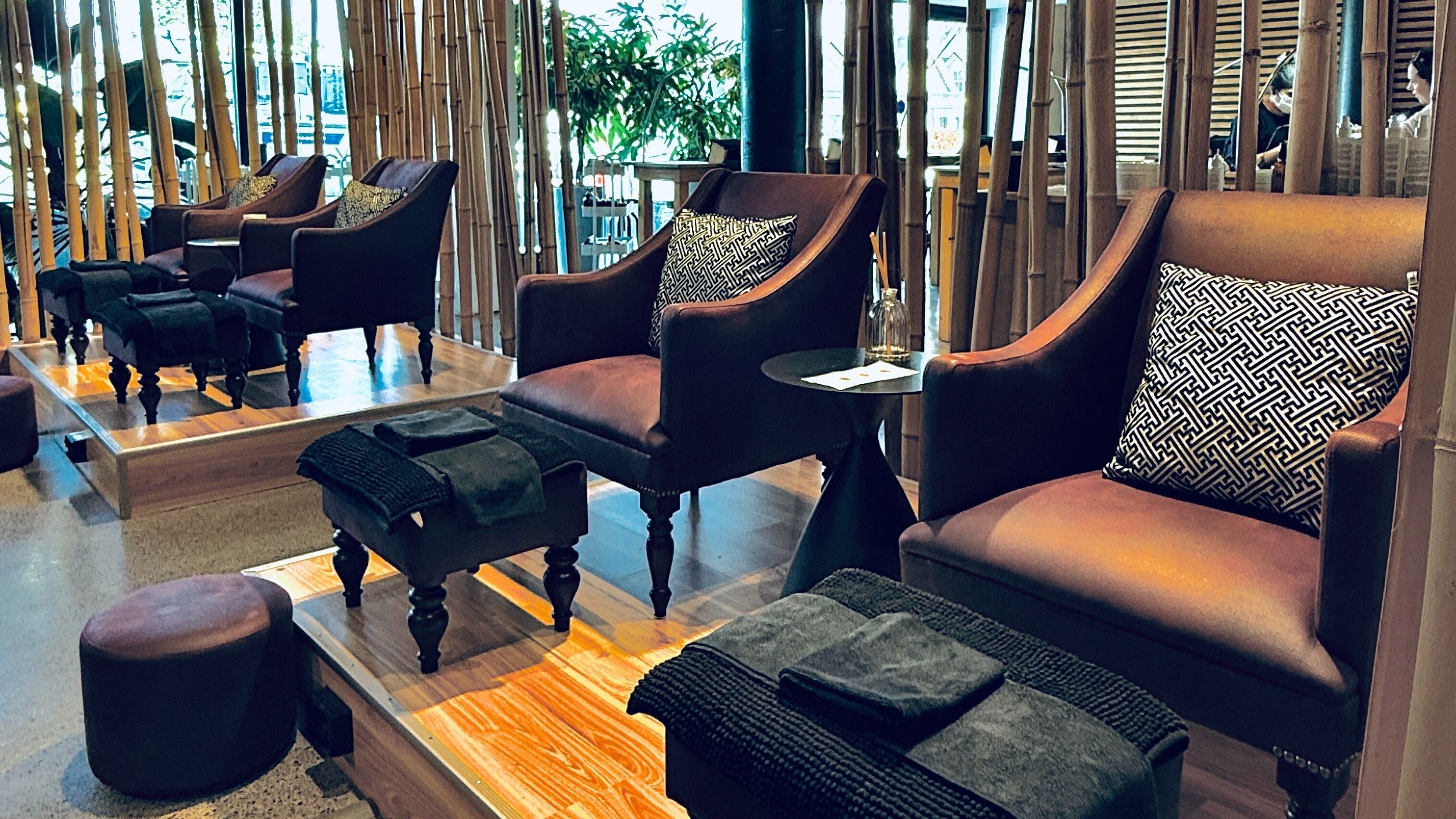 Luxurious seating at The Art of Nails Ponsonby, Auckland, NZ, showcasing plush chairs and bamboo decor.