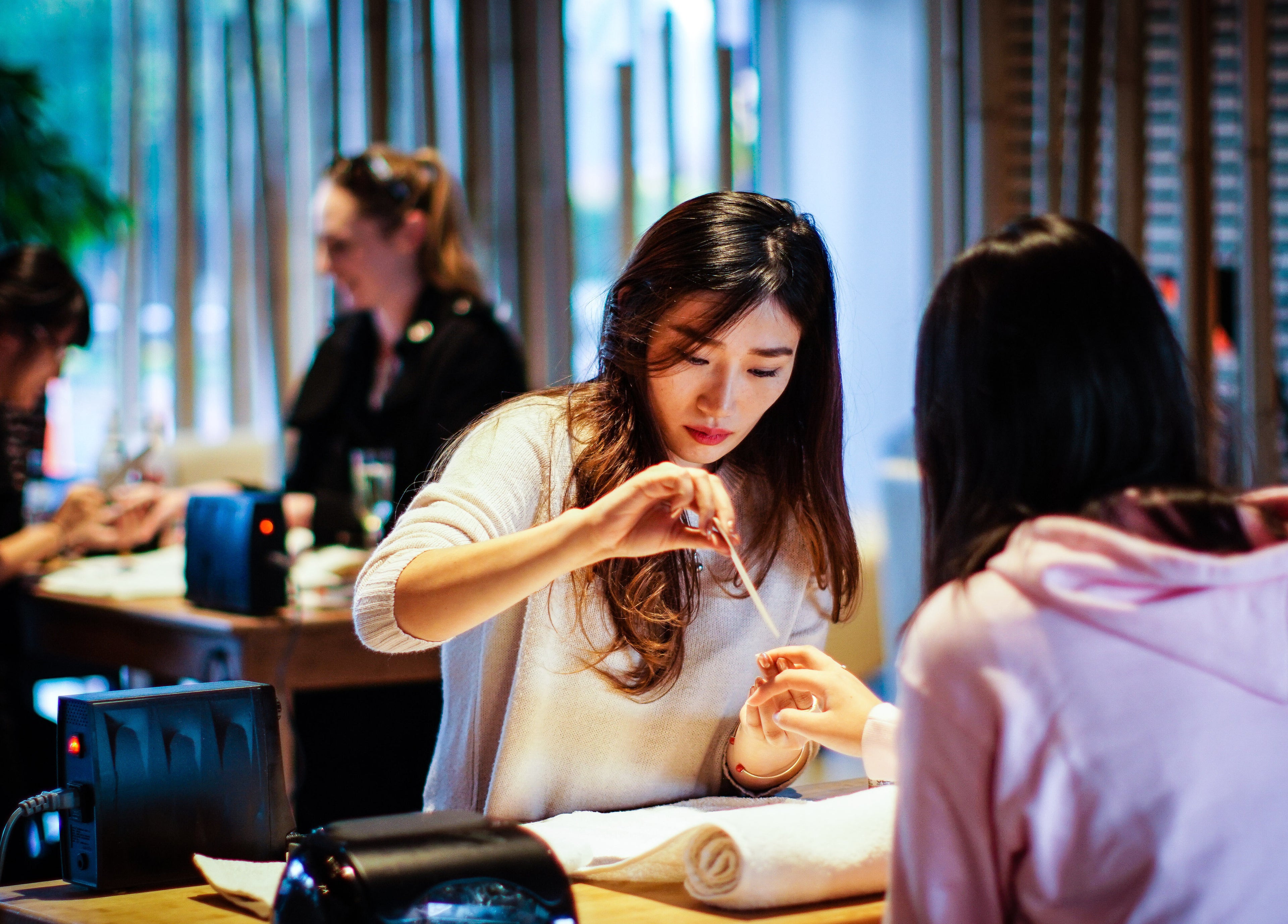 Nail technician at The Art of Nails Ponsonby, Auckland, NZ, providing manicure services in a serene setting.