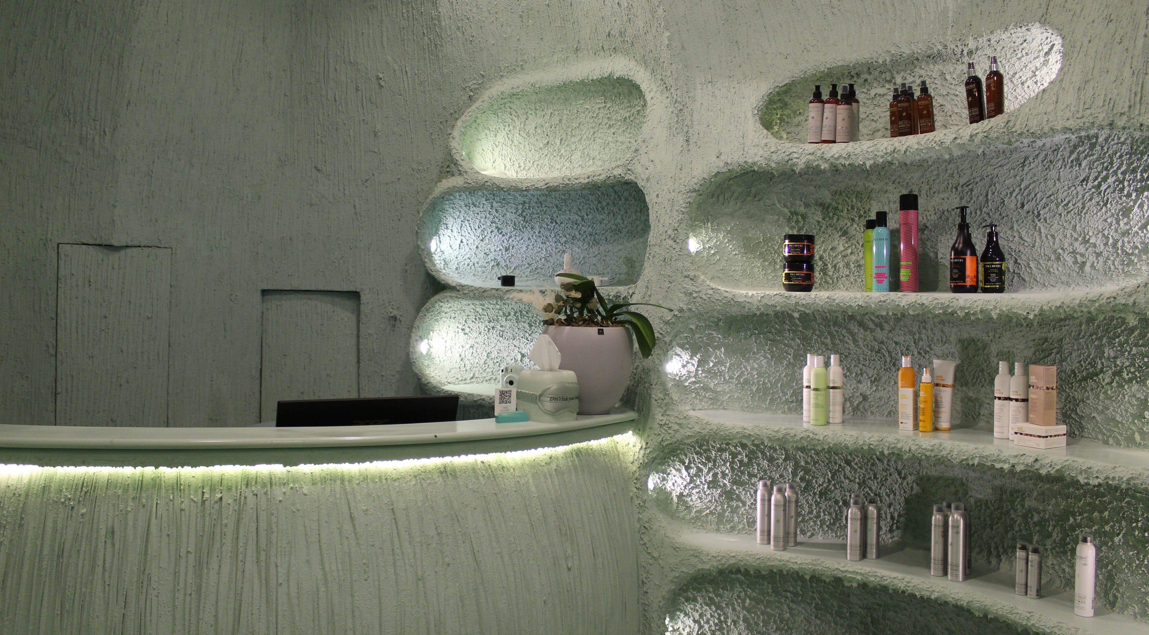 Modern, stylish interior of Hide Beauty Center, Sharjah with shelves of products and gentle lighting.