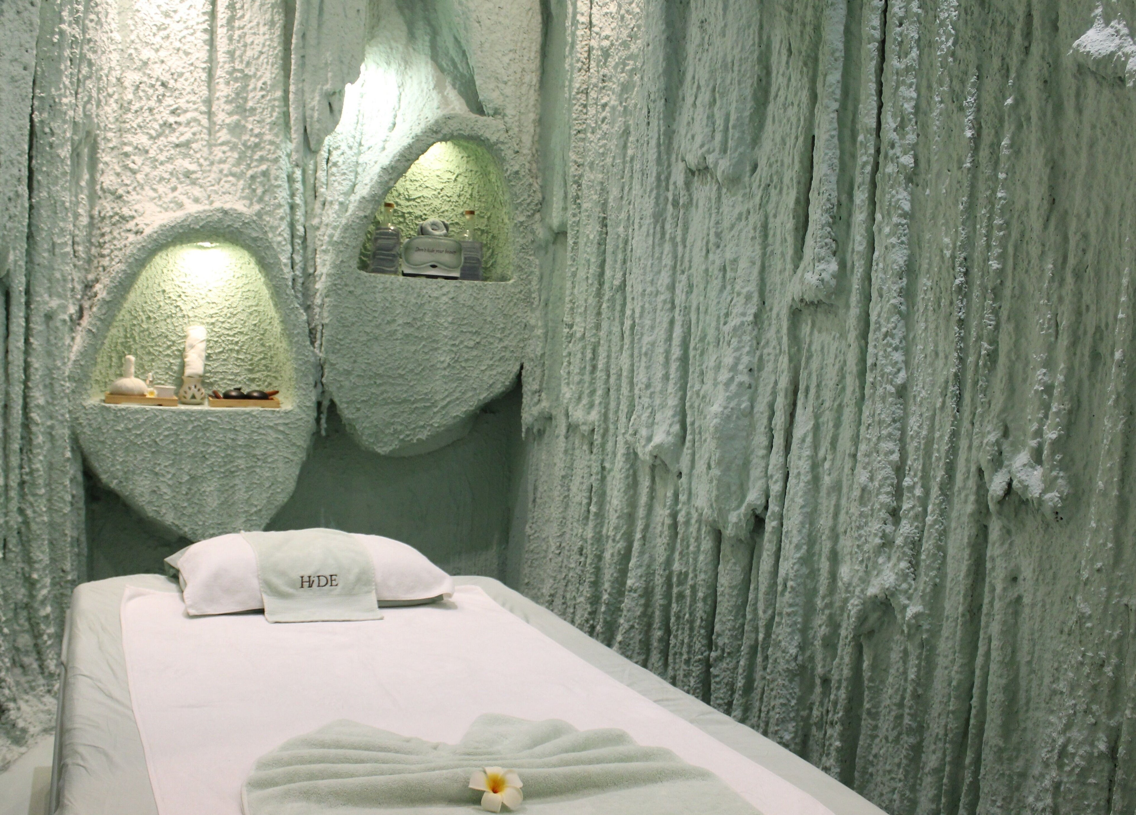 Relaxing therapy room in Hide Beauty Center, Sharjah, Sharjah, AE, with textured walls and comfortable bed.