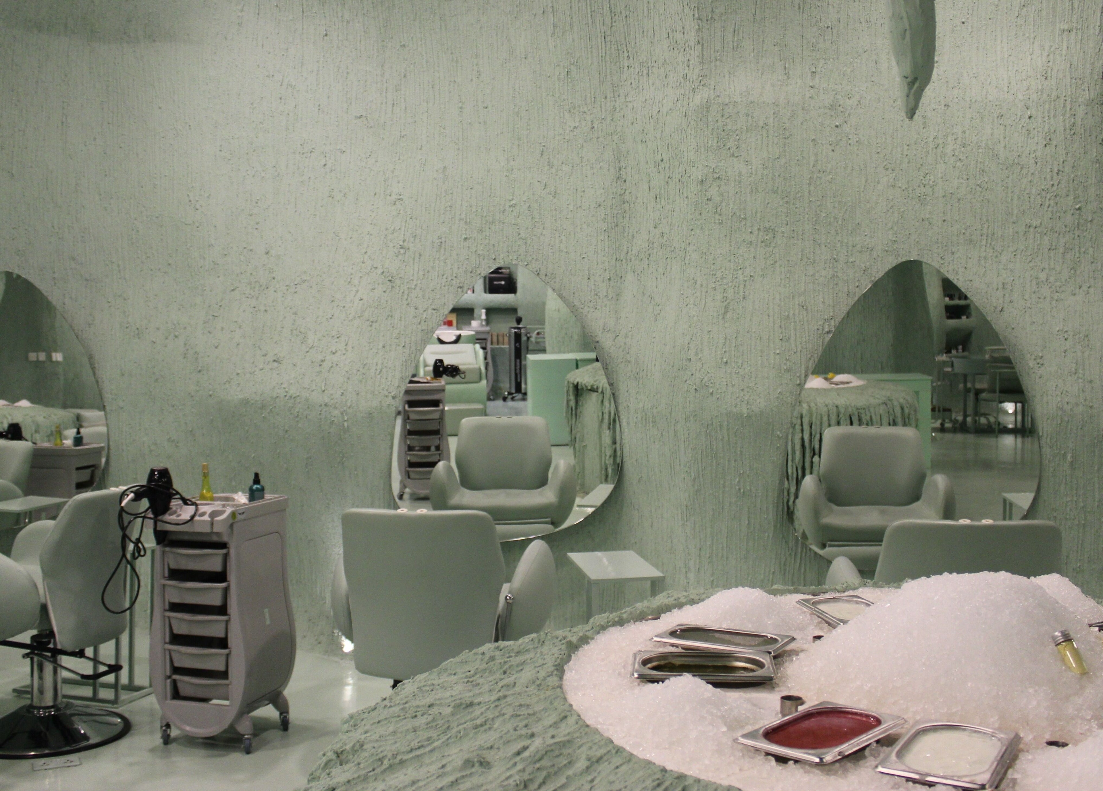 Modern spa interior at Hide Beauty Center, Sharjah, AE with unique mirrors and seating area.