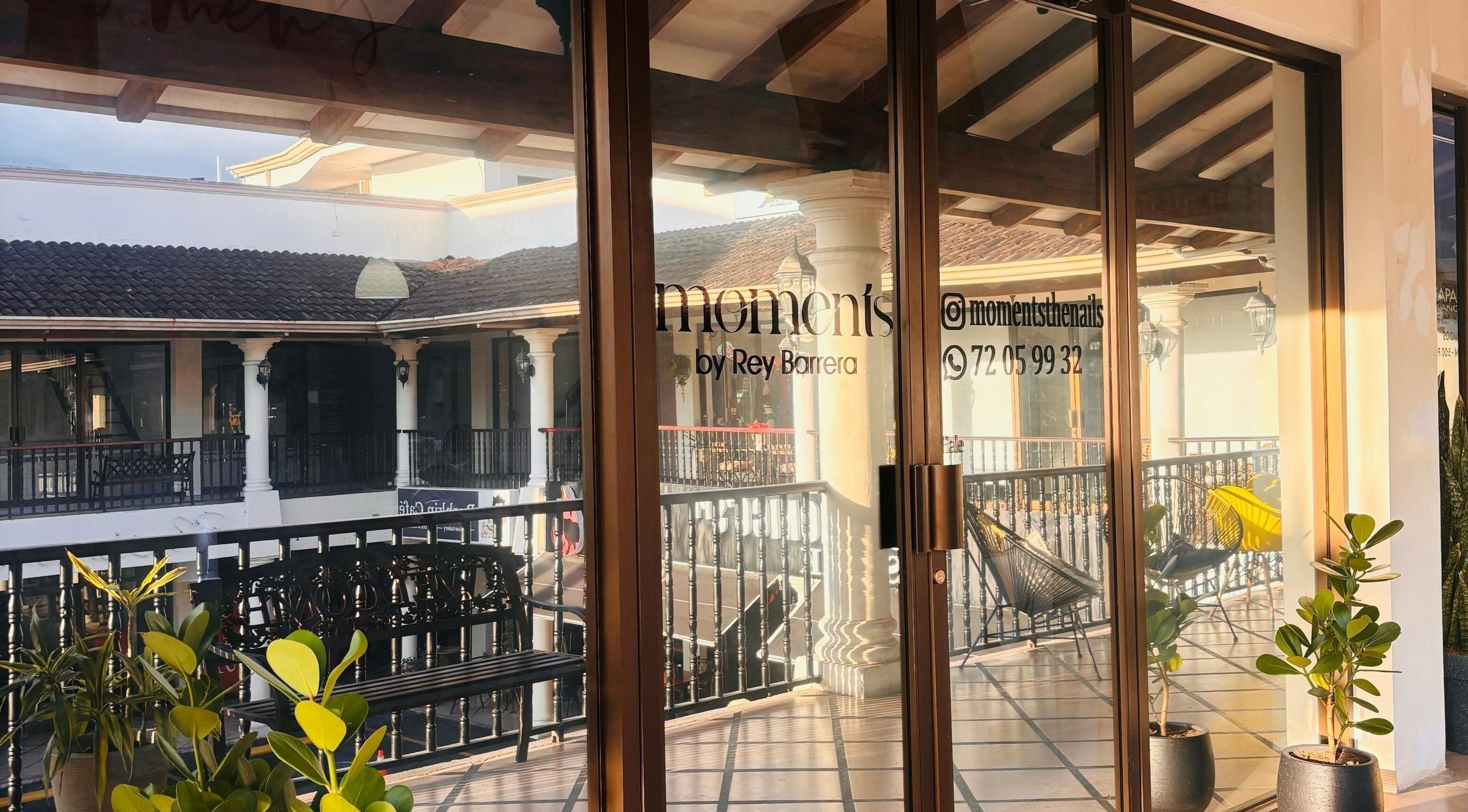 Entrada de Moments The Nails Place Escazu en San Rafael, San José, CR, con plantas y decoración moderna.