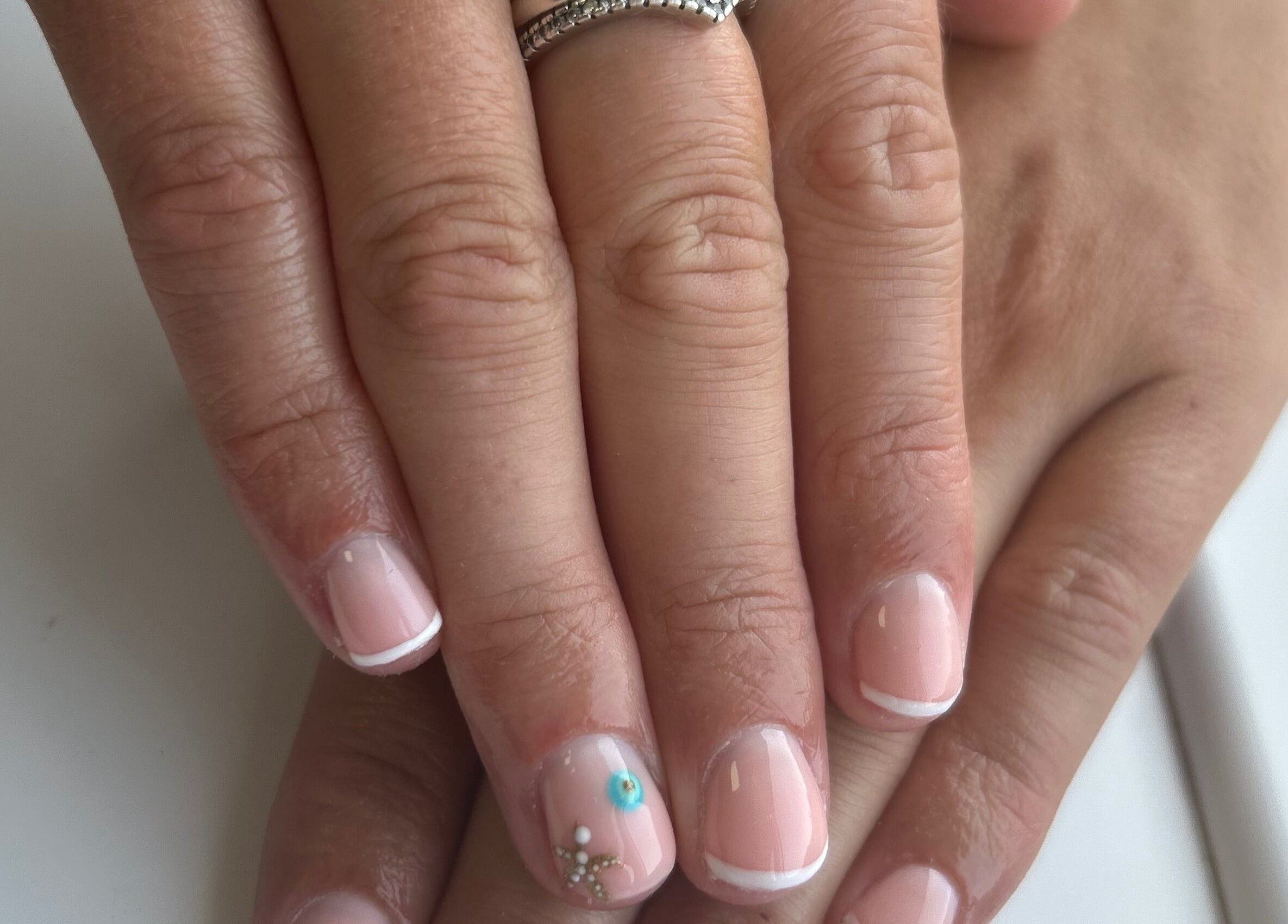 Elegant French manicure with floral accents at Glow By BG, Rotherham, England, GB.