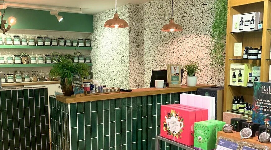 Interior of Balm in Royal Leamington Spa, England; showcasing chic decor with herbal products on display.