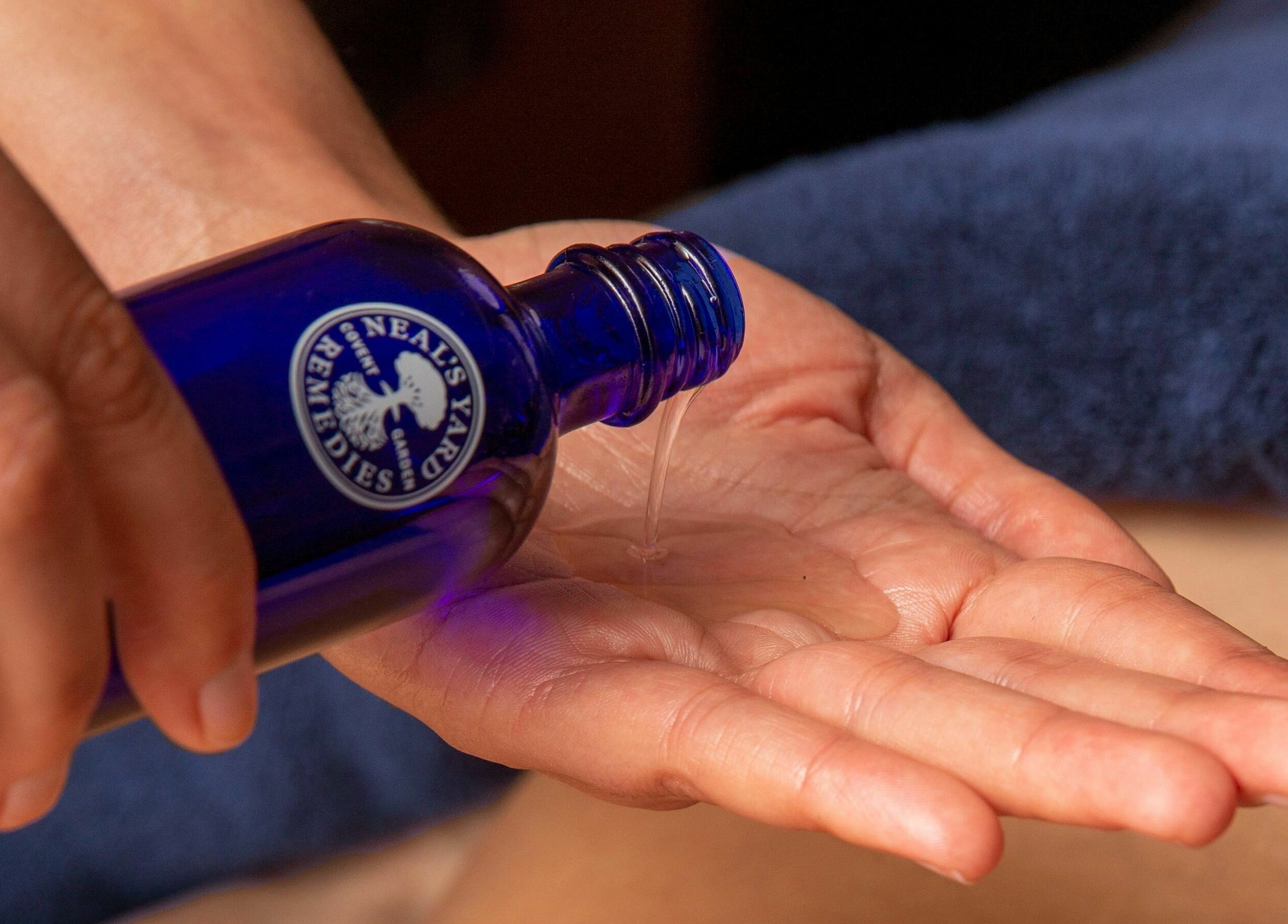 Hand pouring oil at Balm, Royal Leamington Spa, England, GB for a relaxing spa experience.