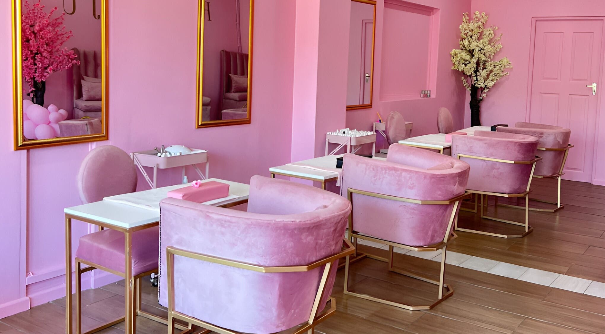 Chic pink interiors of ROZÏÏ JŪ nail salon in East London, Eastern Cape, ZA with plush seating and floral decor.