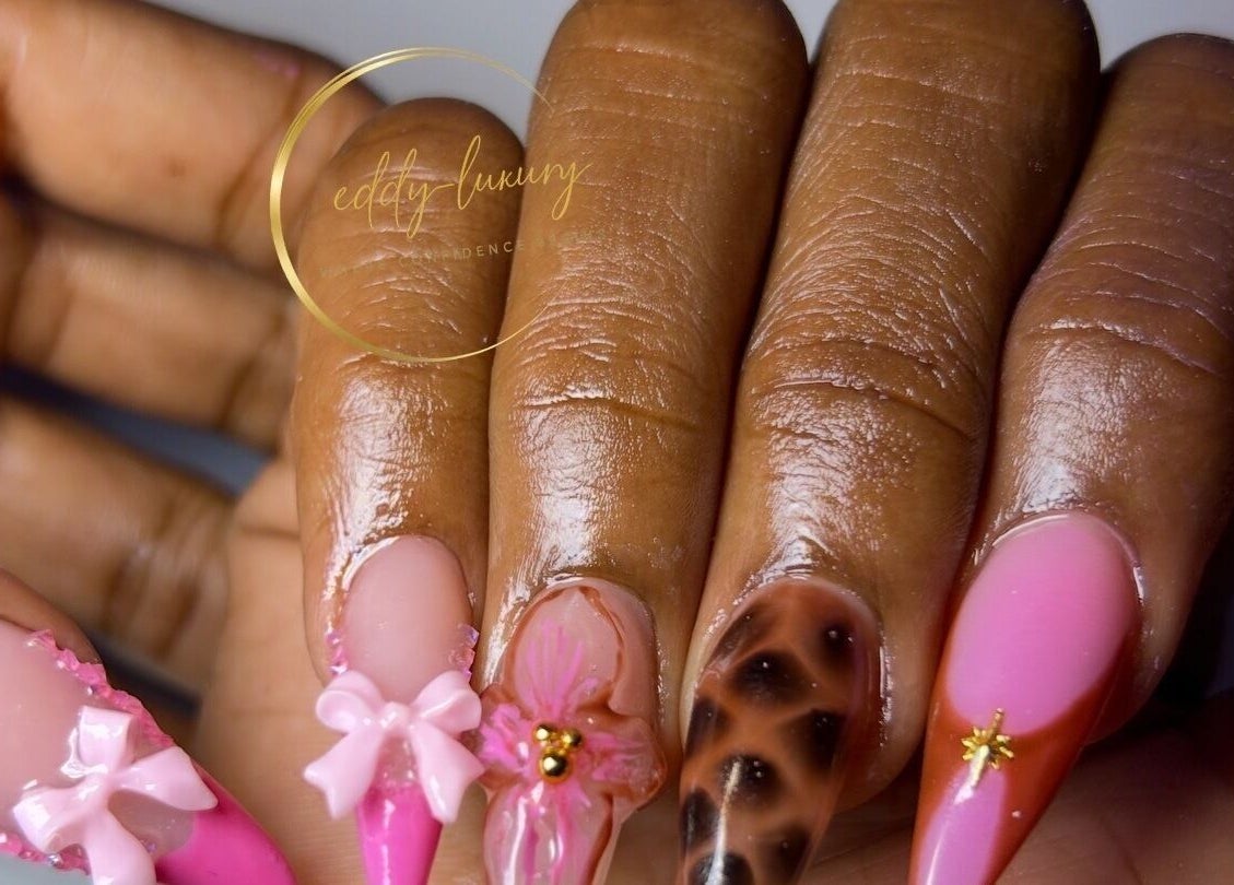 Intricate pink nail art at Eddy_luxury, Portmore, St. Catherine Parish, JM showcasing bow and floral designs.