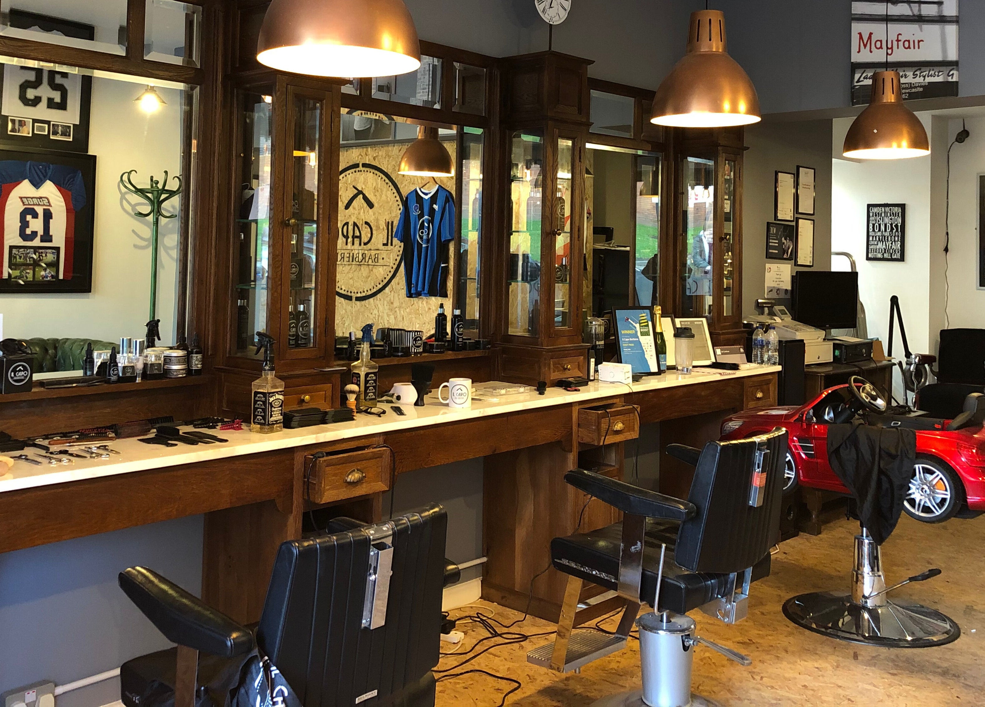 Interior of Il Capo Barbiere, Newcastle-under-Lyme, England, featuring rustic barber chairs and vintage decor.