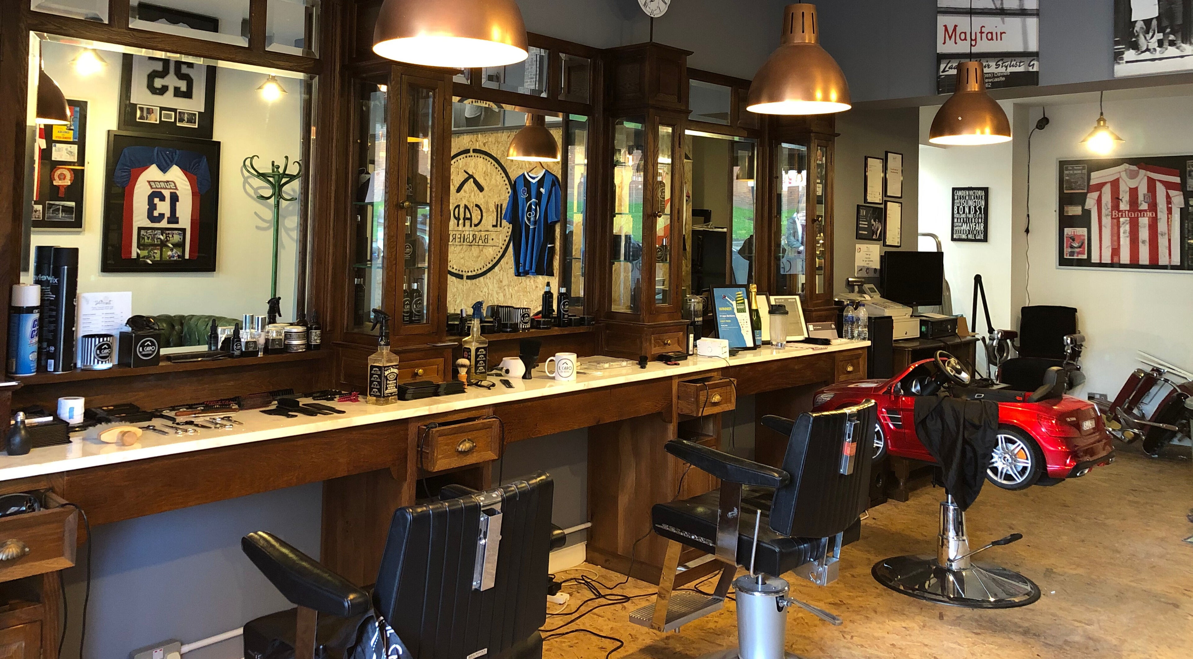 Interior of Il Capo Barbiere, Newcastle-under-Lyme, England, featuring rustic barber chairs and vintage decor.