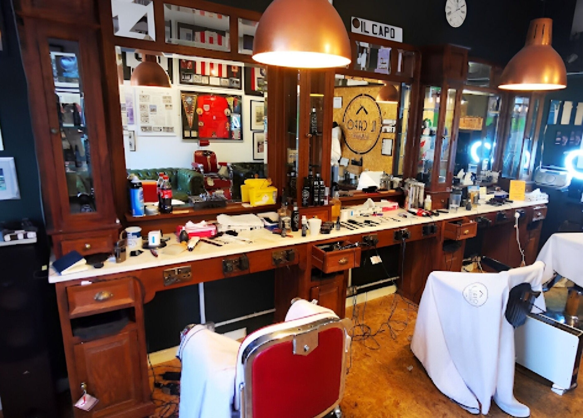 Interior view of Il Capo Barbiere in Newcastle-under-Lyme, England, featuring vintage barber chairs and mirrors.