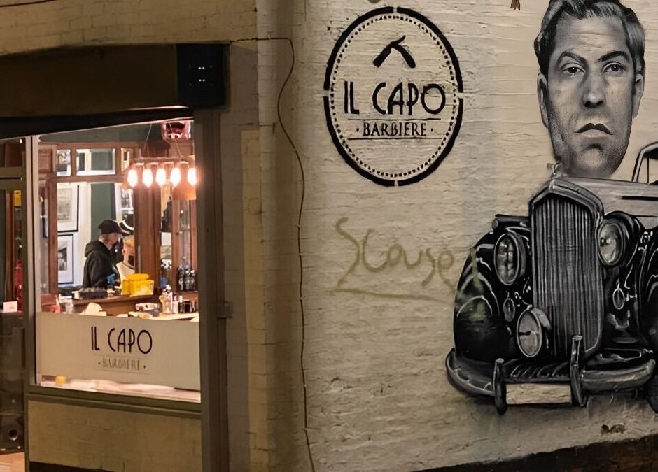 Il Capo Barbiere exterior with retro mural art in Newcastle-under-Lyme, England, GB at night.