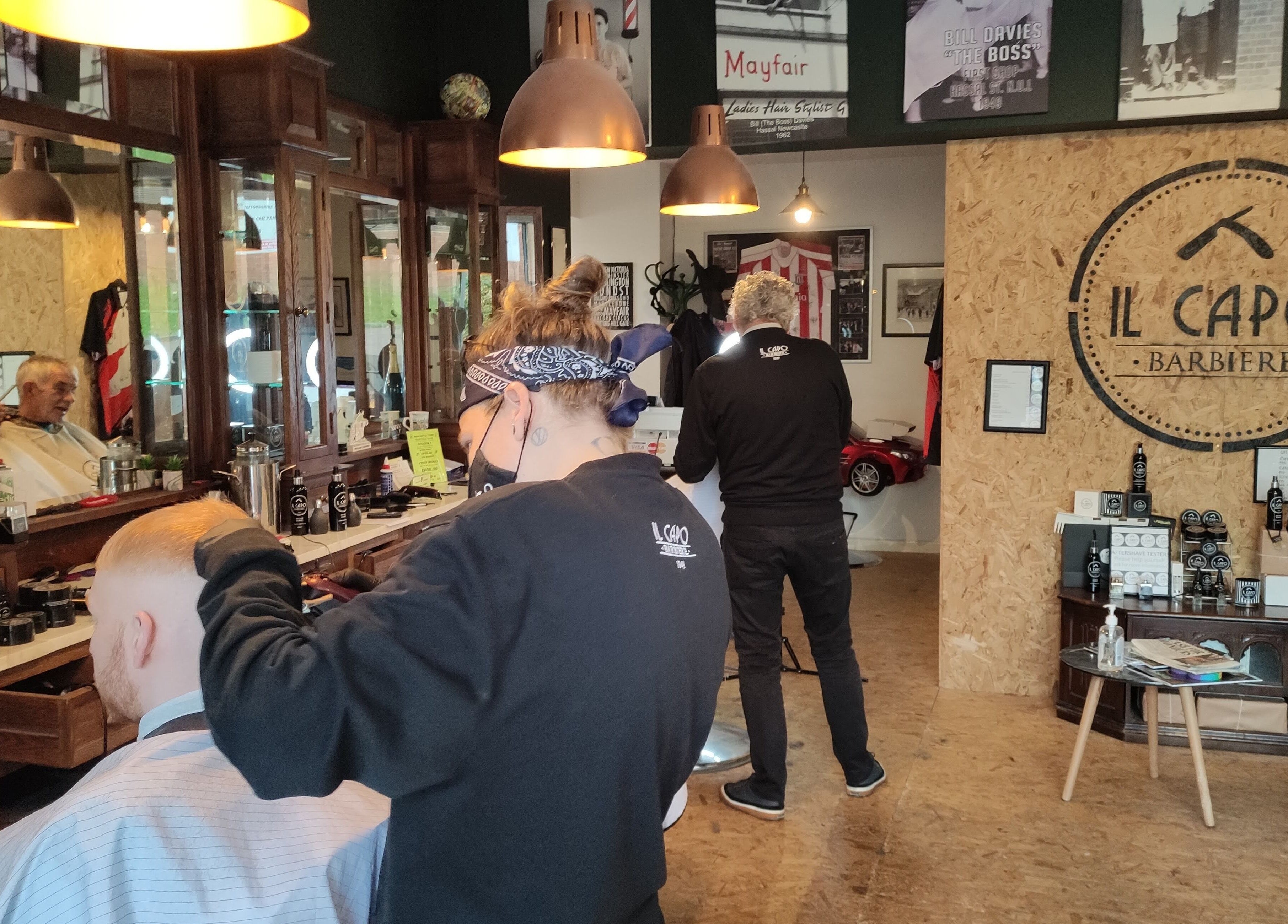 Il Capo Barbiere in Newcastle-under-Lyme, England, GB with customers and stylists in a classic barber setup.