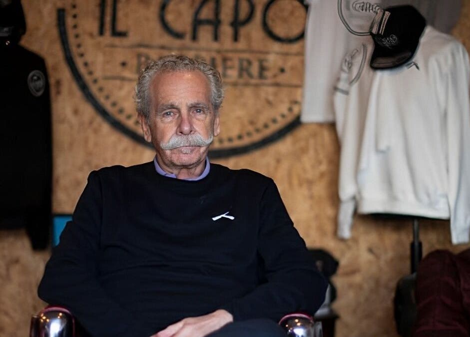 A seasoned barber at Il Capo Barbiere, Newcastle-under-Lyme, England, GB, seated in a cozy, stylish setting.