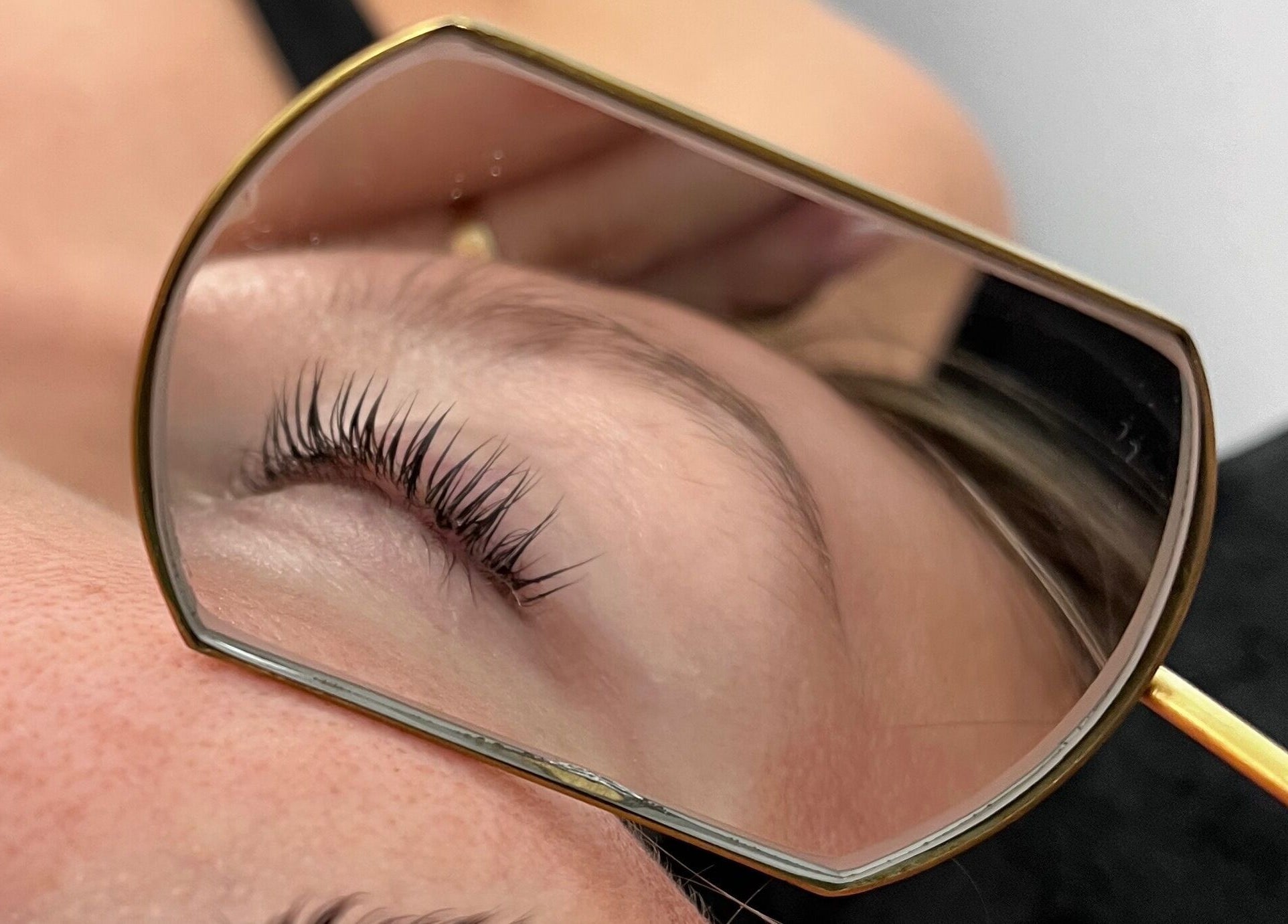 Cils parfaitement relevés au Espace Cils + à Boucherville, Québec, CA, reflétés dans un miroir doré.