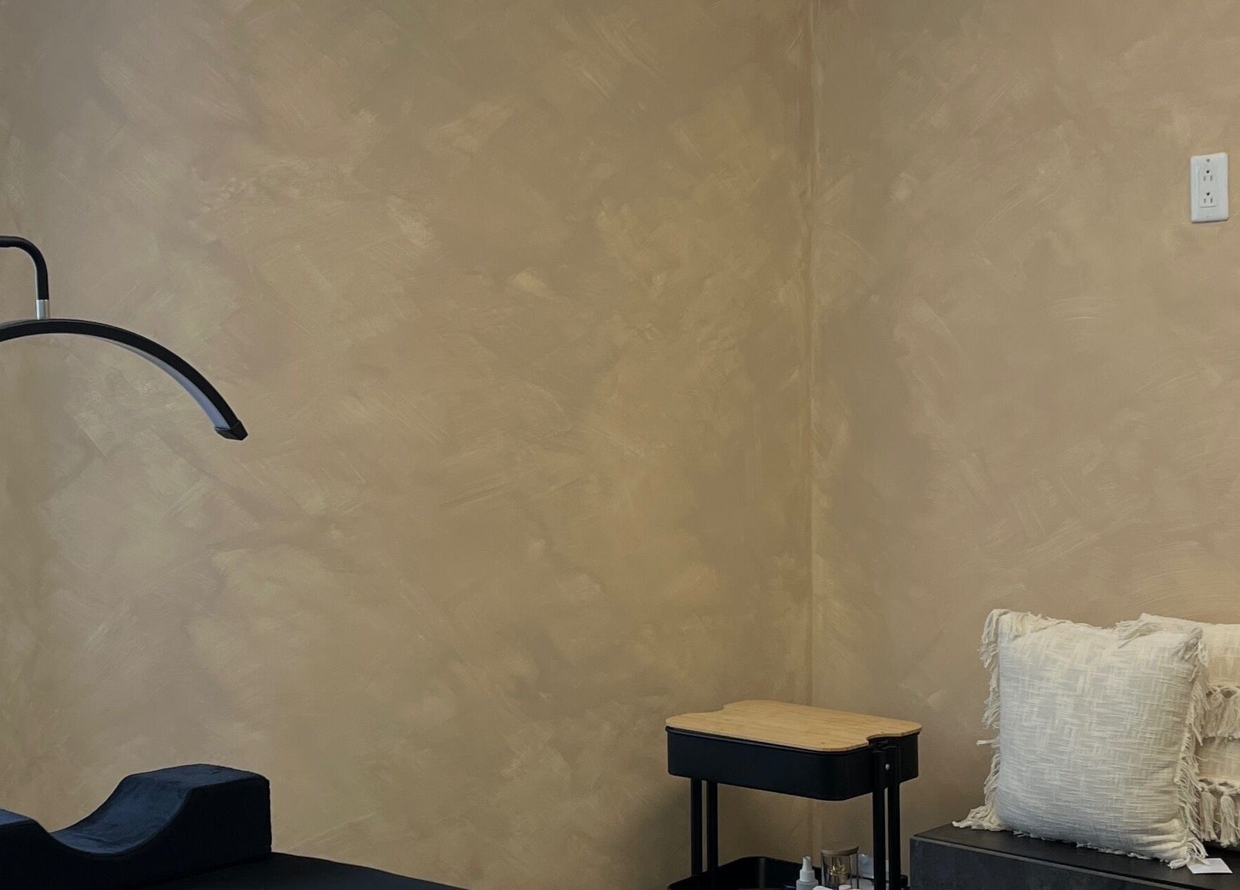 Espace Cils + à Boucherville, Québec, CA, cabine de soins avec coussins et table élégante.