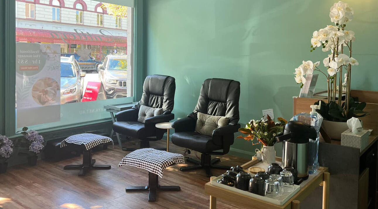 Cozy seating area at Cattleya Thai Massage & Waxing in Melbourne, Victoria, AU, with massage chairs and orchids.