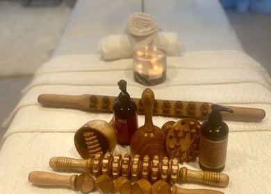 Wooden massage tools and oils on a spa table at Tina Magic | Home Service Muscat, Muscat, Muscat Governorate, OM.