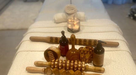 Wooden massage tools and oils on a spa table at Tina Magic | Home Service Muscat, Muscat, Muscat Governorate, OM.