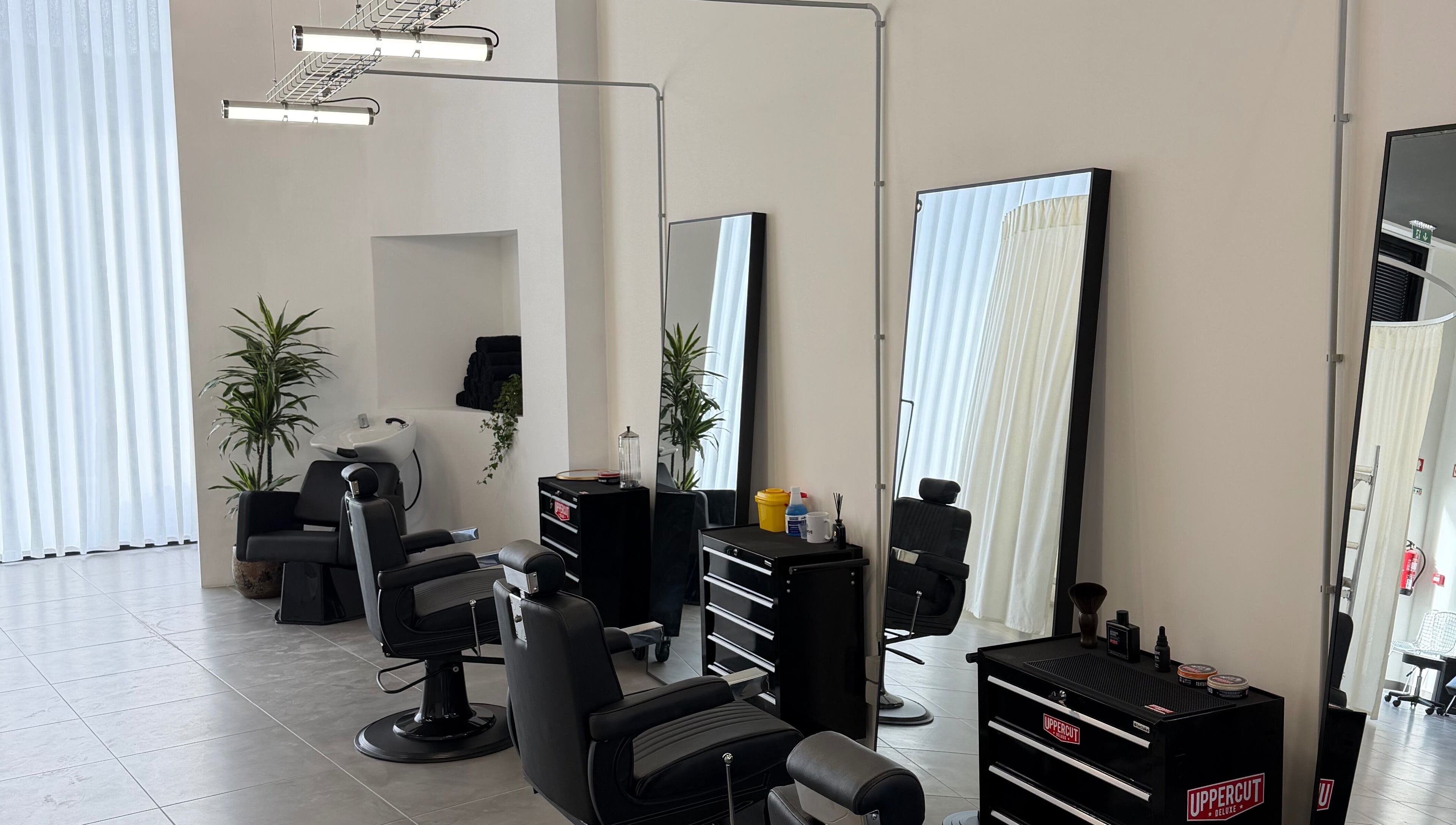 Interior moderno do salão Nuno’s Lab Aveiro em Aveiro, Aveiro, PT, com cadeiras de barbeiro.