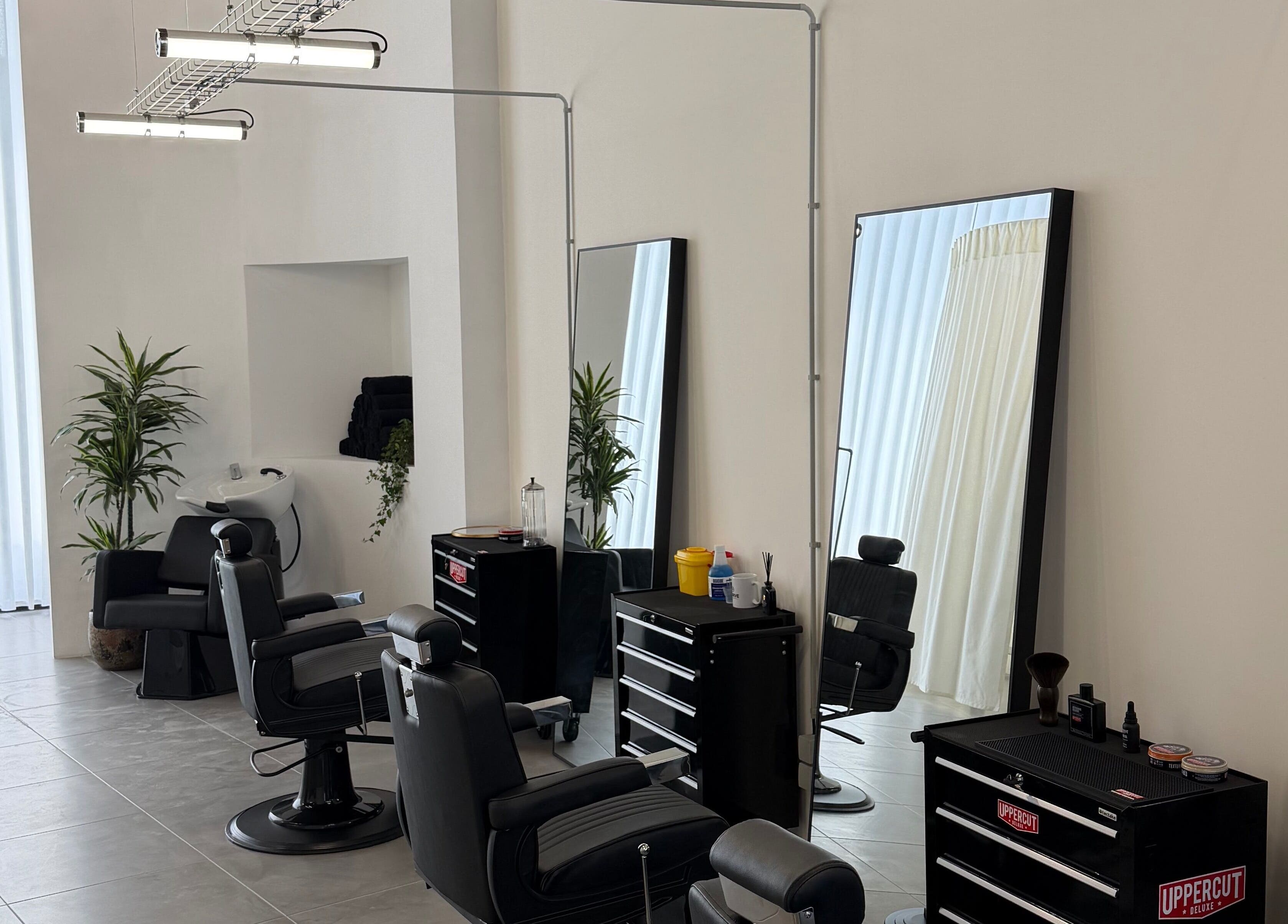 Interior moderno do salão Nuno’s Lab Aveiro em Aveiro, Aveiro, PT, com cadeiras de barbeiro.