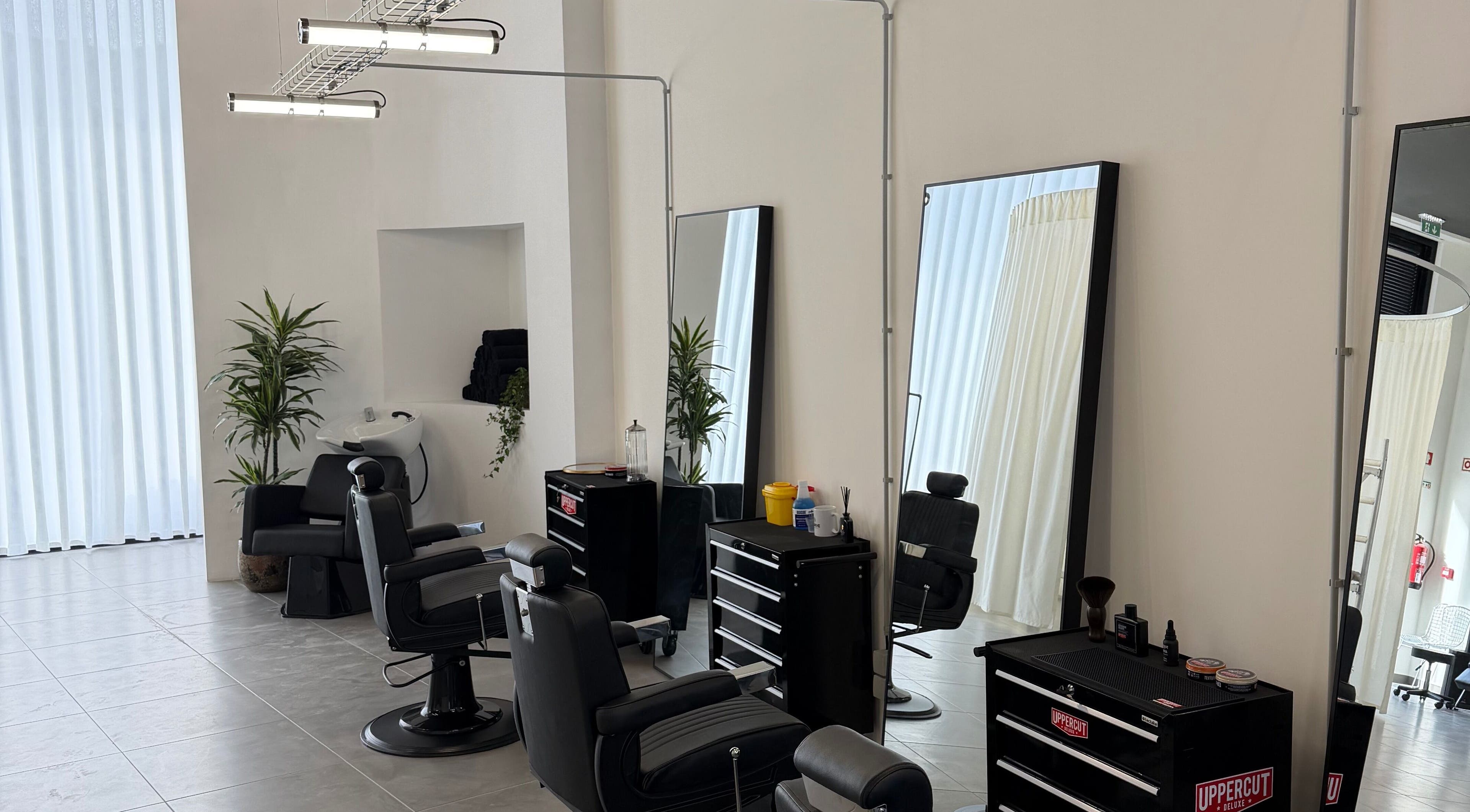 Sala elegante do salão Nuno’s Lab Aveiro em Aveiro, Aveiro, PT, com cadeiras de cabeleireiro e espelhos.