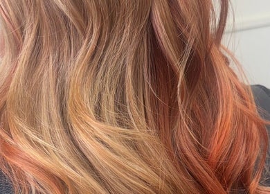 Stylish warm-toned wavy hair from Kim A Hair, Masham, England, GB, showcasing expert coloring and styling.