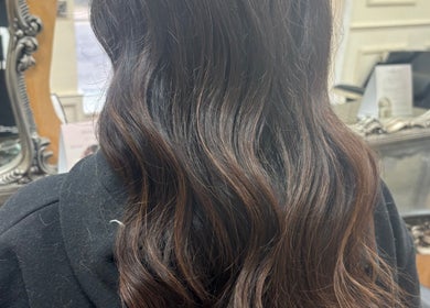 Smooth, elegant brown waves styled at Kim A Hair in Masham, England, GB, reflecting expert hairstyling.