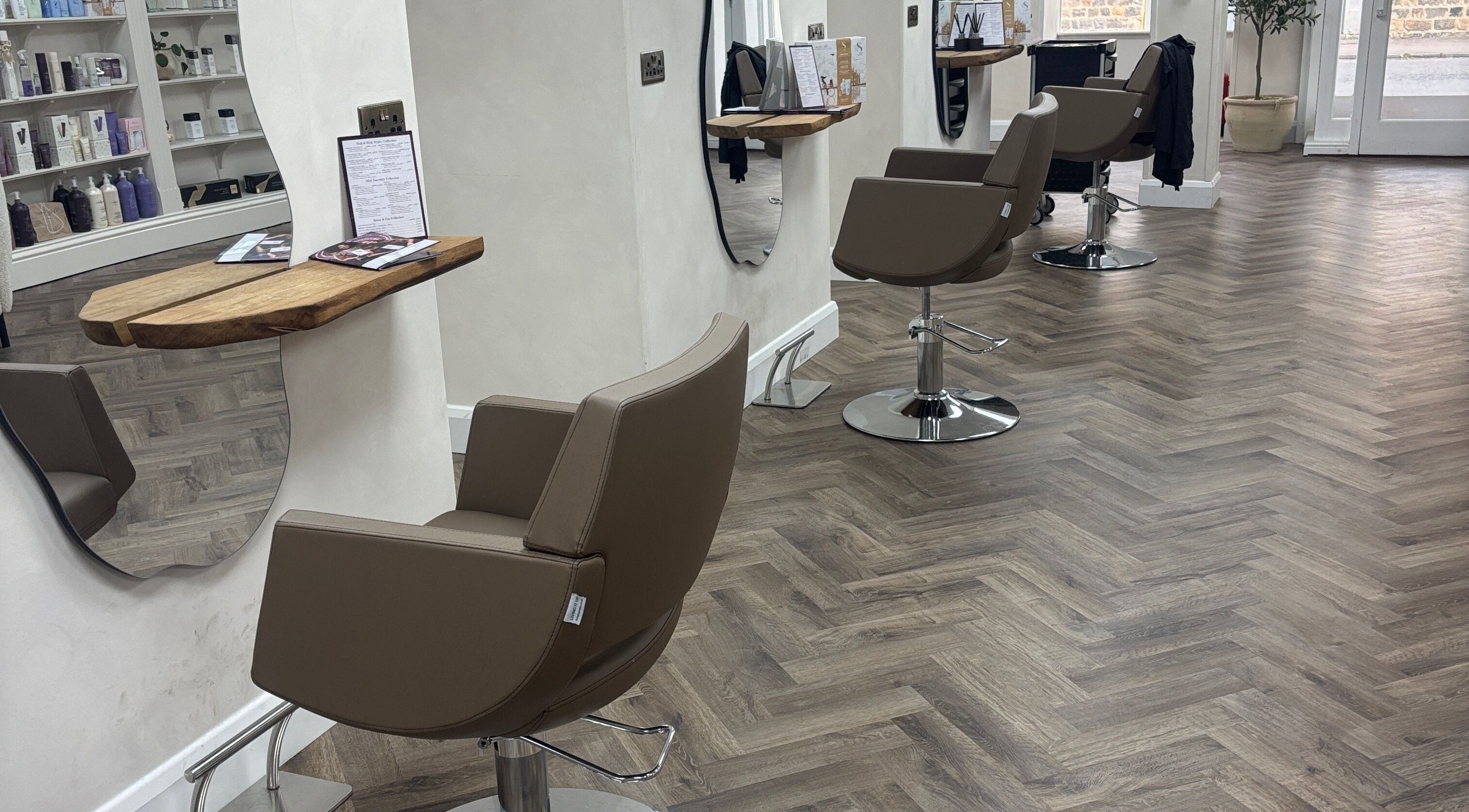 Modern interior of Kim A Hair salon in Masham, England, GB with styling chairs and mirrors.