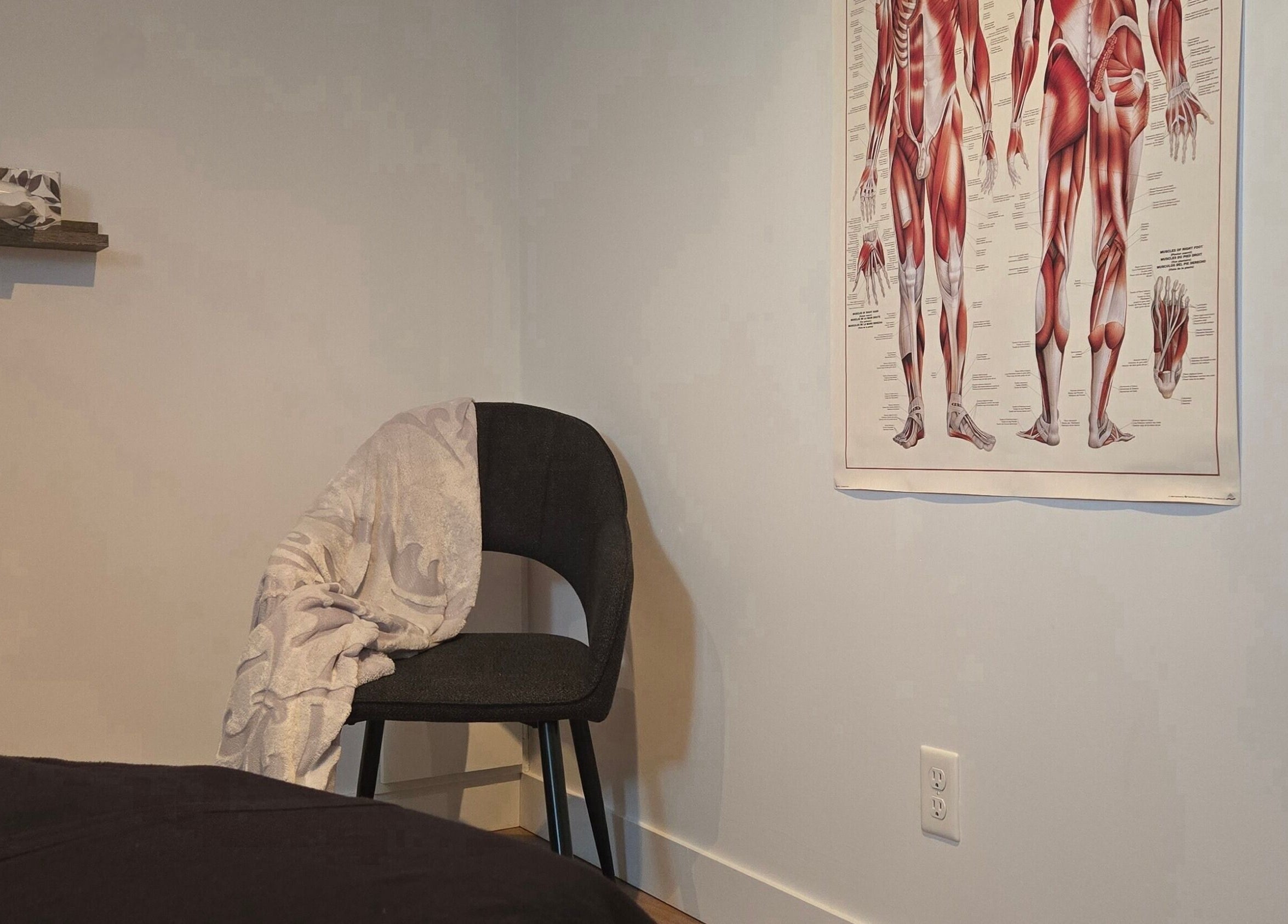 Salle de traitement à Clinique Gabrielle Bérubé, Saint-tite, Québec, CA avec chaise et affiche anatomique.