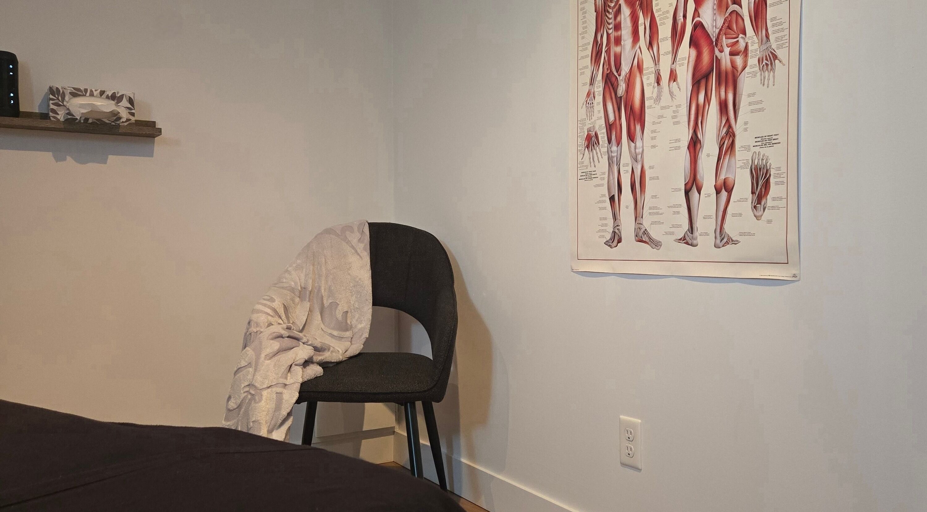 Salle de traitement à Clinique Gabrielle Bérubé, Saint-tite, Québec, CA avec chaise et affiche anatomique.