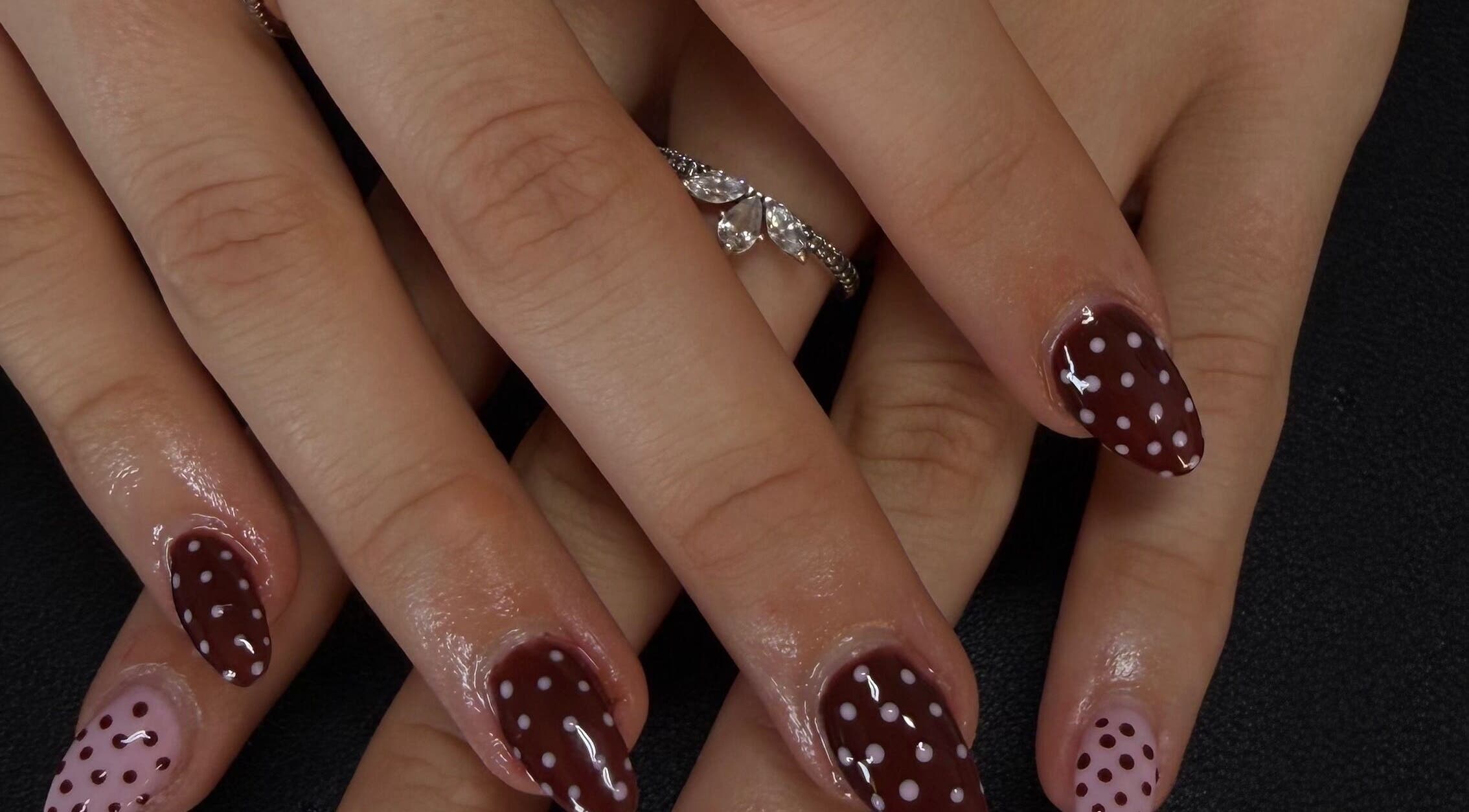 Polka dot nail art on hands at Dlux Beauty Bar, Laidley, Queensland, AU.